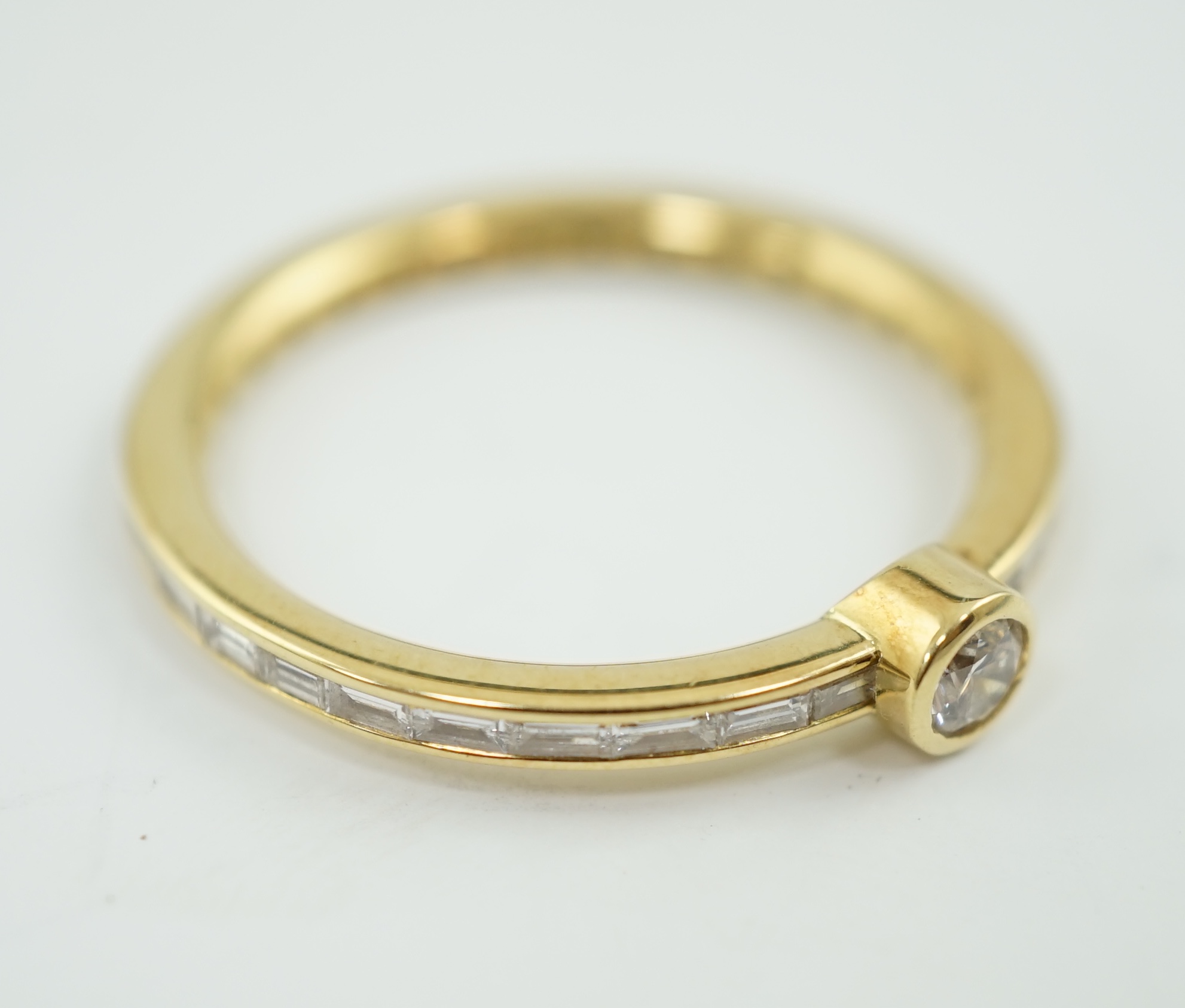 A modern 18ct gold, round and baguette cut diamond set ring